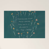 "Through Sun And Rain, You Will Bloom All The Same." Welcome Mat