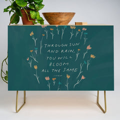 "Through Sun And Rain, You Will Bloom All The Same." Credenza