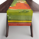 A female attendant is standing in tribhanga pose under a tree. A small child vies for her attention. Table Runner