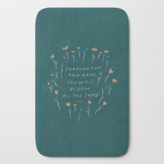 "Through Sun And Rain, You Will Bloom All The Same." Bath Mat