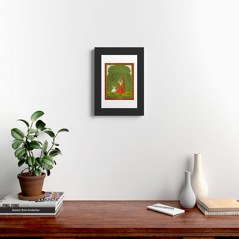 A female attendant is standing in tribhanga pose under a tree. A small child vies for her attention. Framed Art Print
