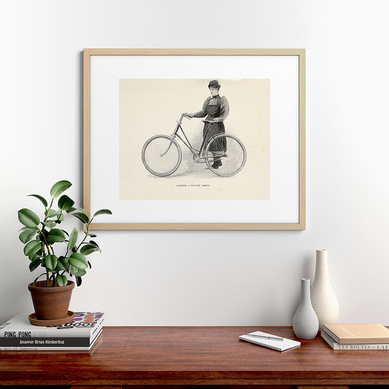 "Leading a Bicycle About" from "Bicycling for Ladies" by Maria E. Ward, 1896 Framed Art Print