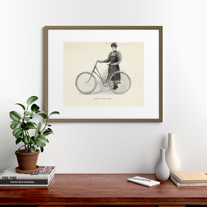 "Leading a Bicycle About" from "Bicycling for Ladies" by Maria E. Ward, 1896 Framed Art Print